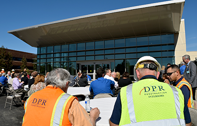 DPR workers and NorthBay employees sit down in front of the new Welcome Pavilion at NBMC to enjoy a barbecue.